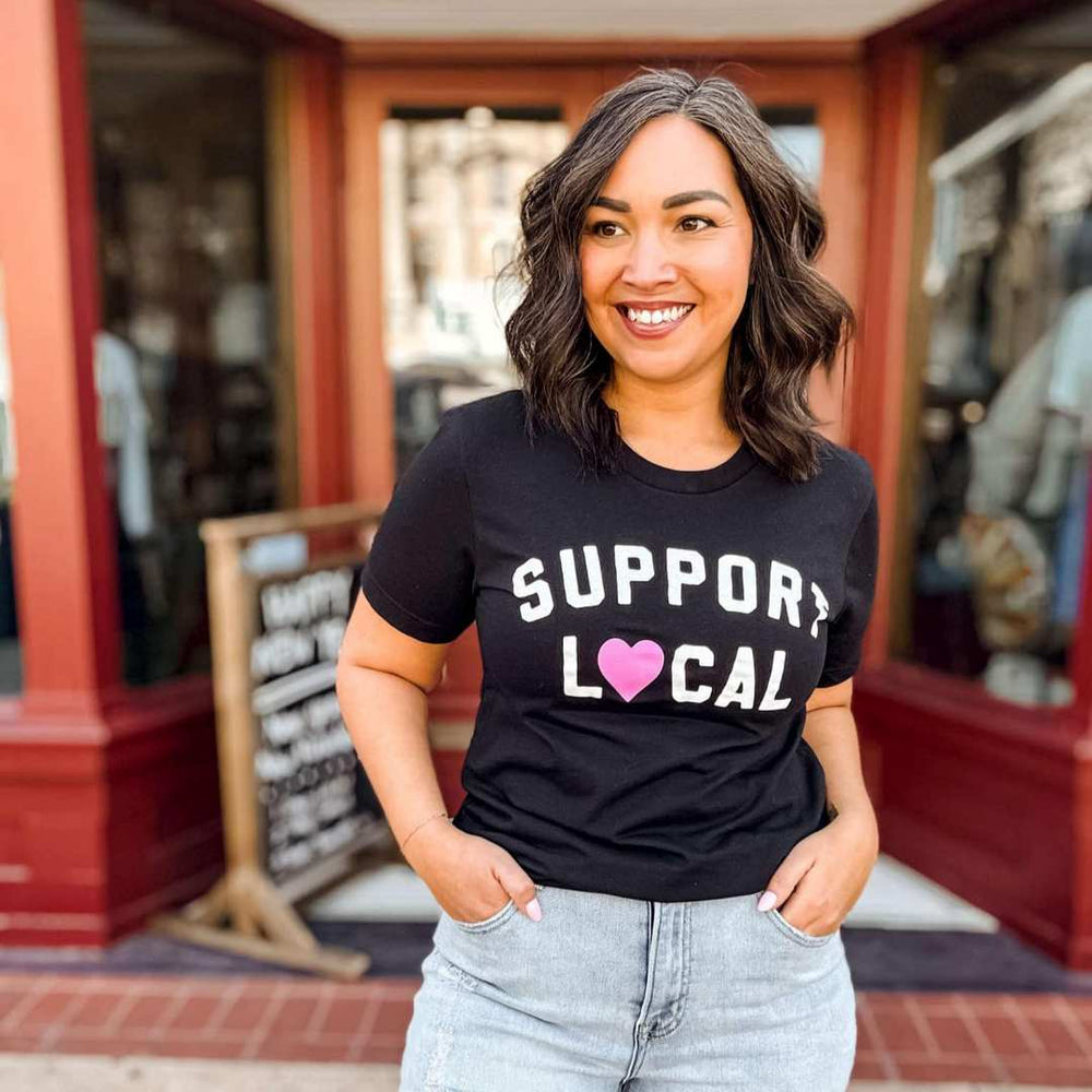 Mugsby | Support Local Tee | A black shirt with white text and a heart as the O in "Local"