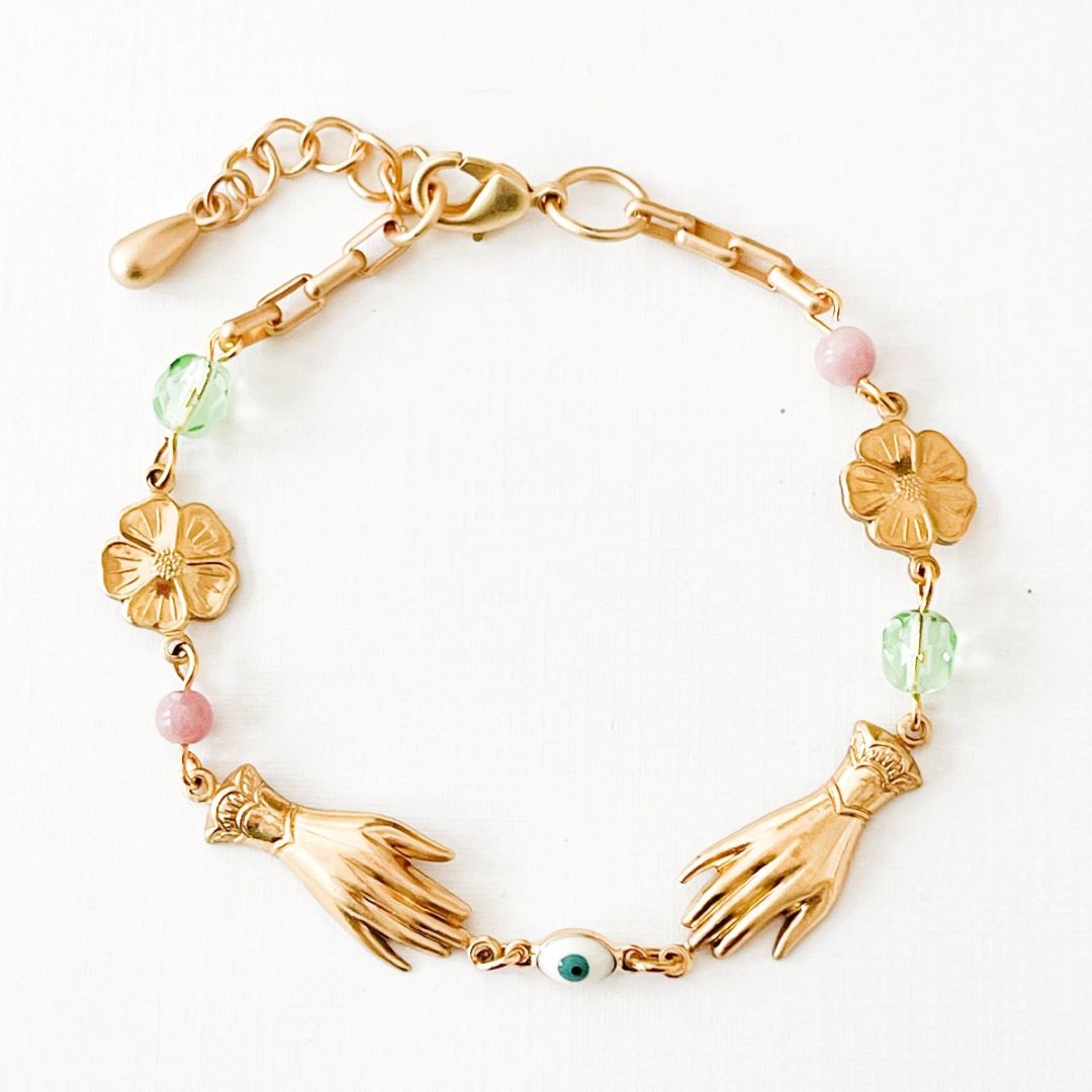 Adjustable Pastel and Flower Charm Bracelet for Spring | Nest Pretty Things | A gold bracelet with charms with green and pink accents.