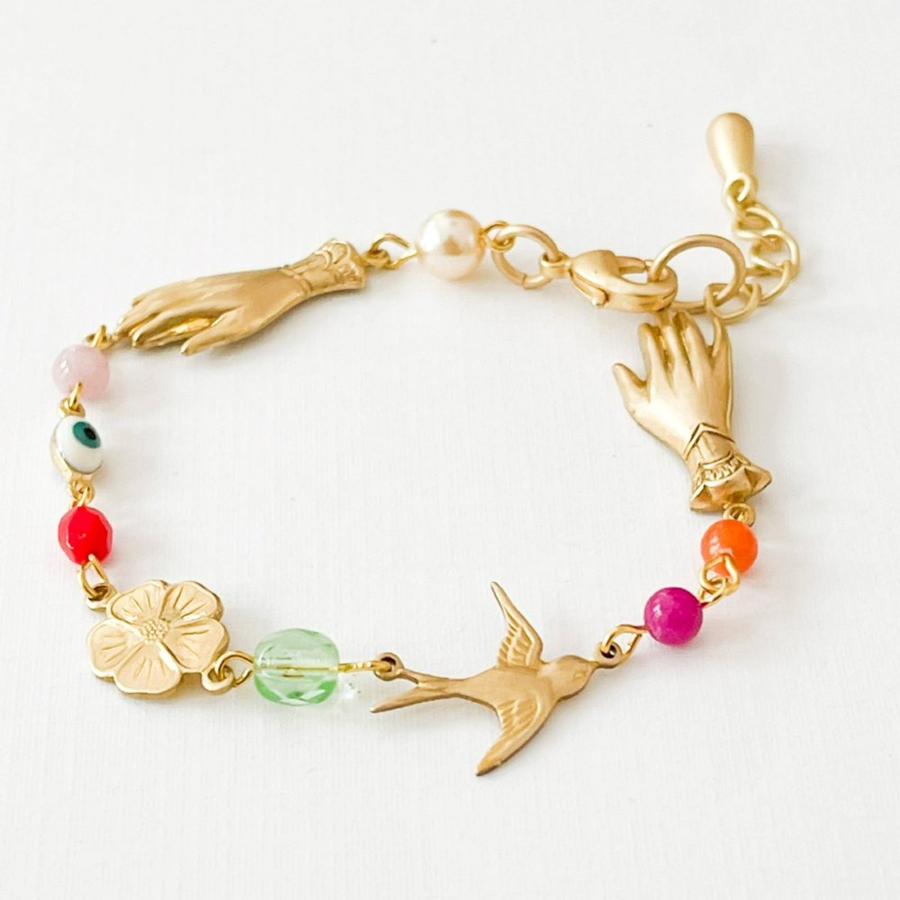 Nest Pretty Things | A gold colored bracelet with charms and beads.