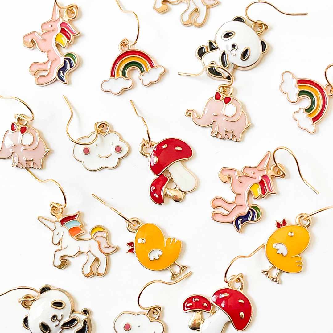 Nest Pretty Things | Colorful earrings including unicorns, rainbows, and mushrooms on a white background