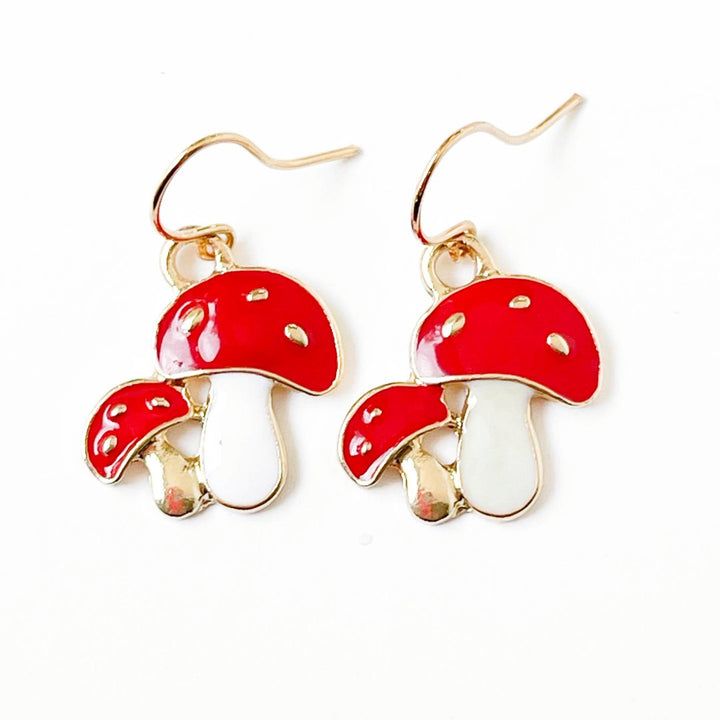 Nest Pretty Things | Mushroom-shaped earrings with red caps and white stems on a white background