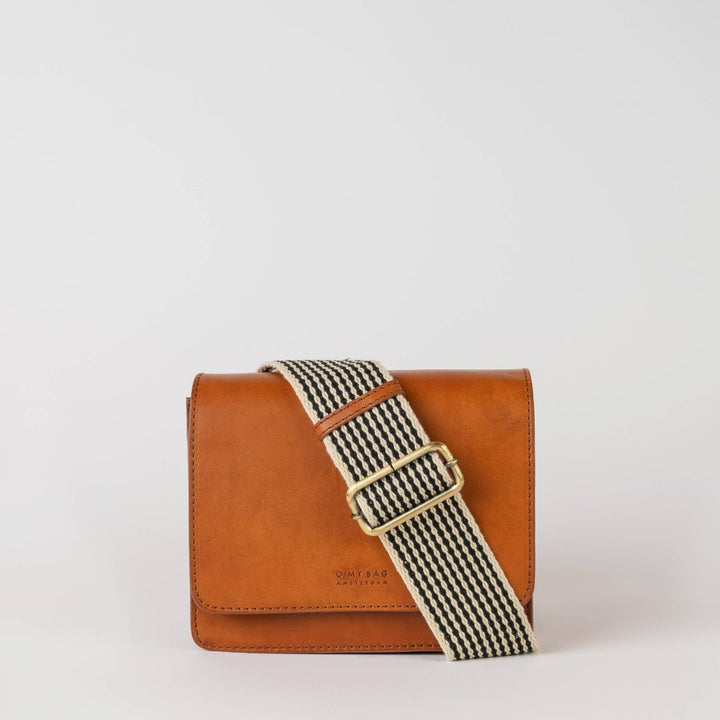 O My Bag | Audrey Mini | Cognac leather bag with a black and white striped strap.