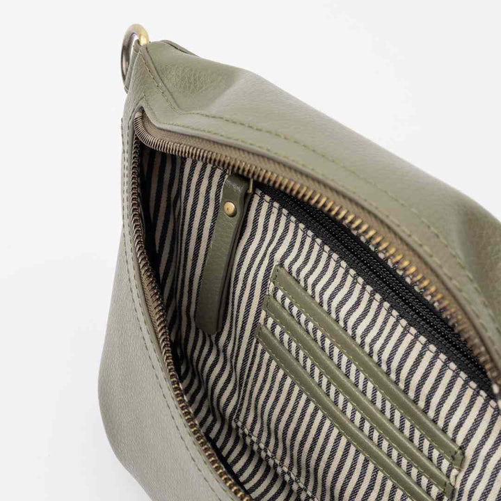 O My Bag | Milo Sage Green Crossbody Bag | Close-up of a green leather pouch with striped lining on a white background