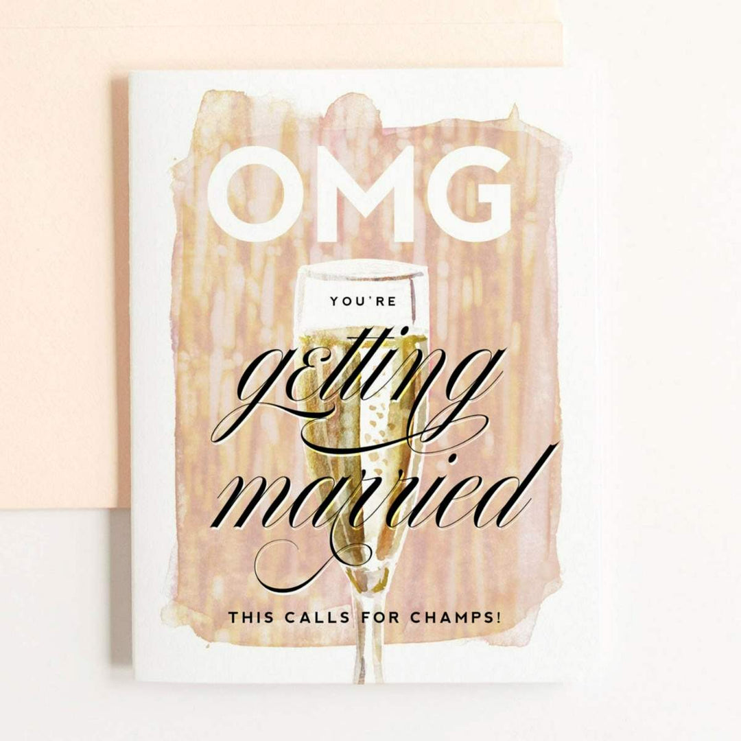 A soft tinsel patterned card with and illustrated champagne glass and text that reads "OMG you're getting married. This calls for champs!".