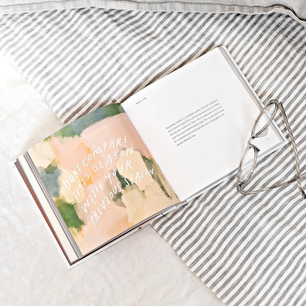 Open book with floral design on a striped fabric surface