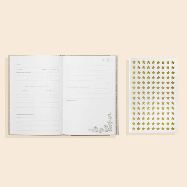 Open planner with star stickers on a beige background