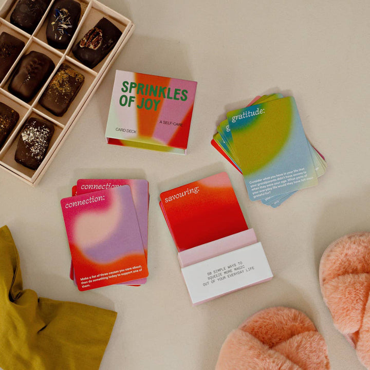 Colorful cards with text and a box of chocolates on a light surface