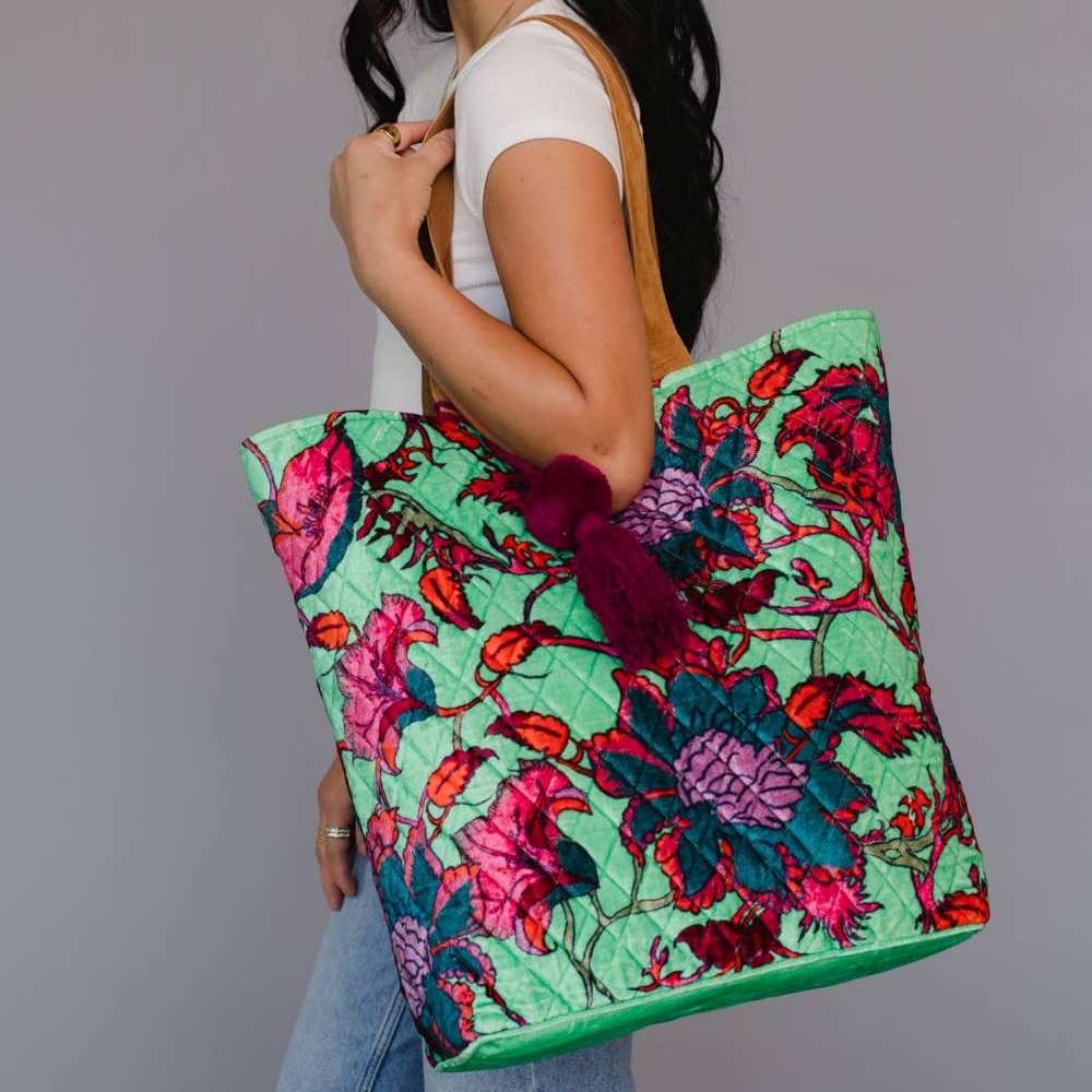 Panache Apparel Co. | Person holding a colorful green floral tote bag with a plain background