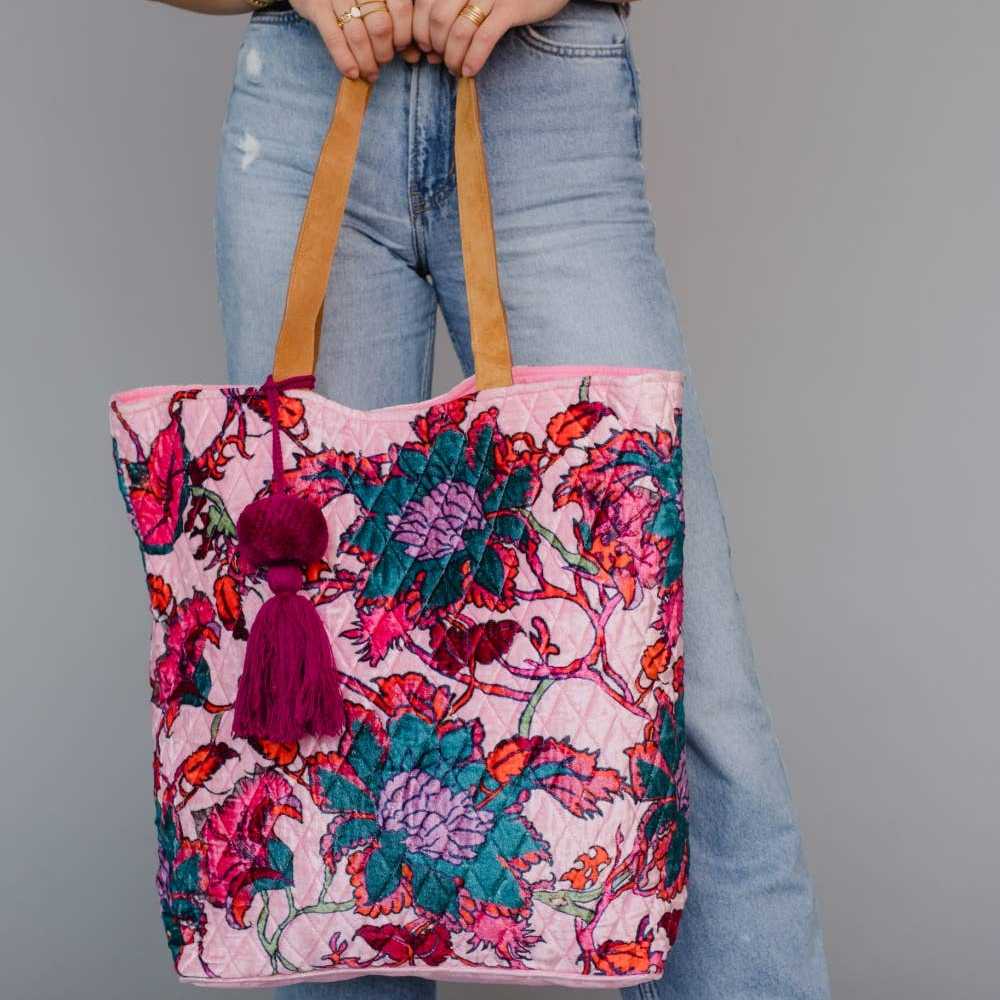 Panache Apparel Co. | Person holding a colorful floral tote bag against a gray background