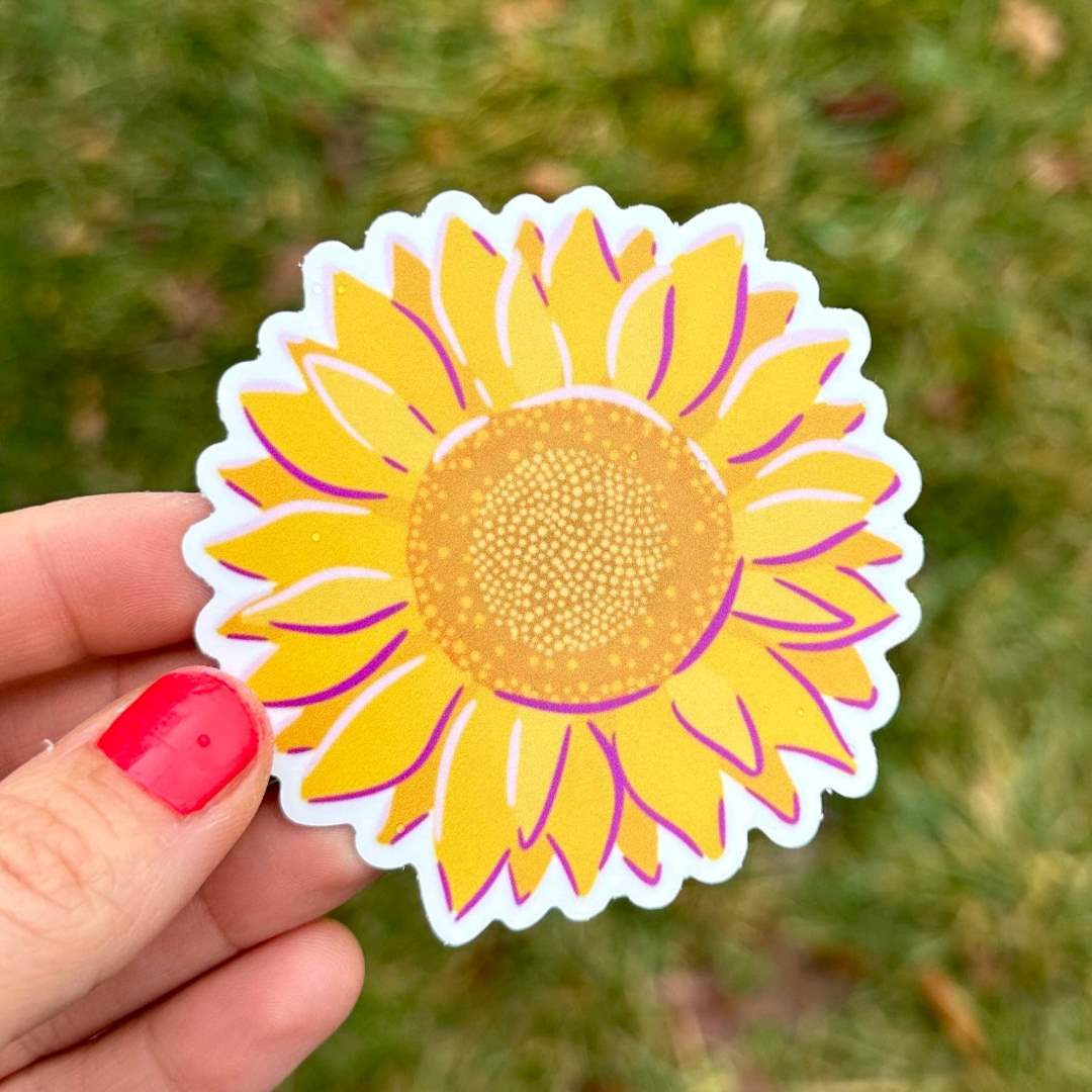 Piccolo Press | Sunflower Sticker held against a grass background.