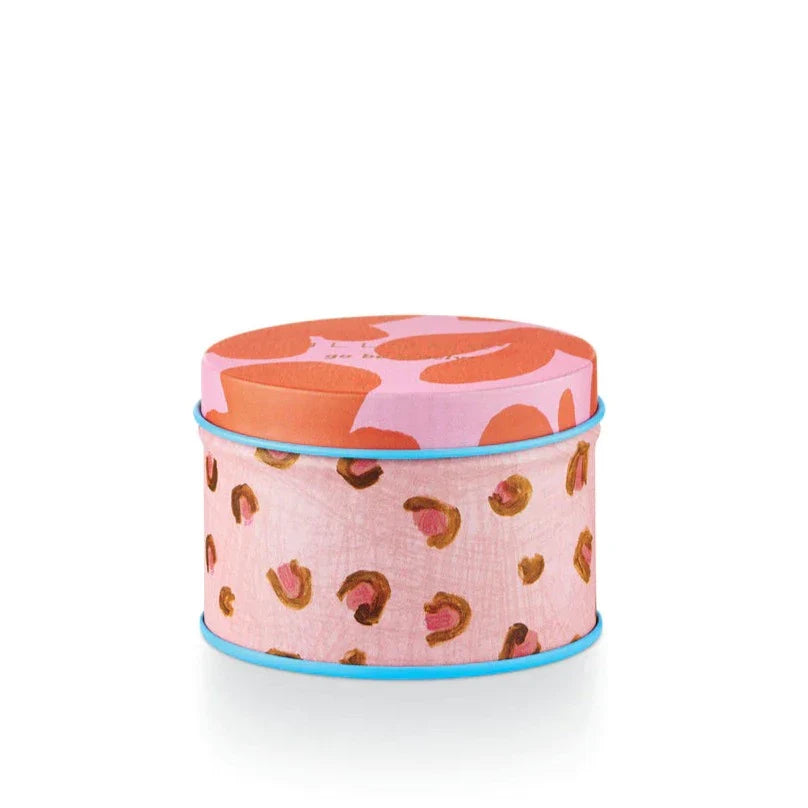 Illume | Pink Pepper Fruit Tin Candle | A pink patterned tin with floral, cheetah print, and a bright blue accent rim.