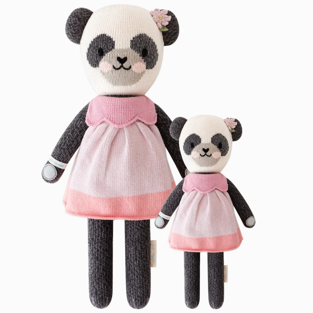 Polly the Panda | Cuddle + Kind | A black and white panda with a pink dress and flower behind the ear. Two sizes pictured, 20" and 13".