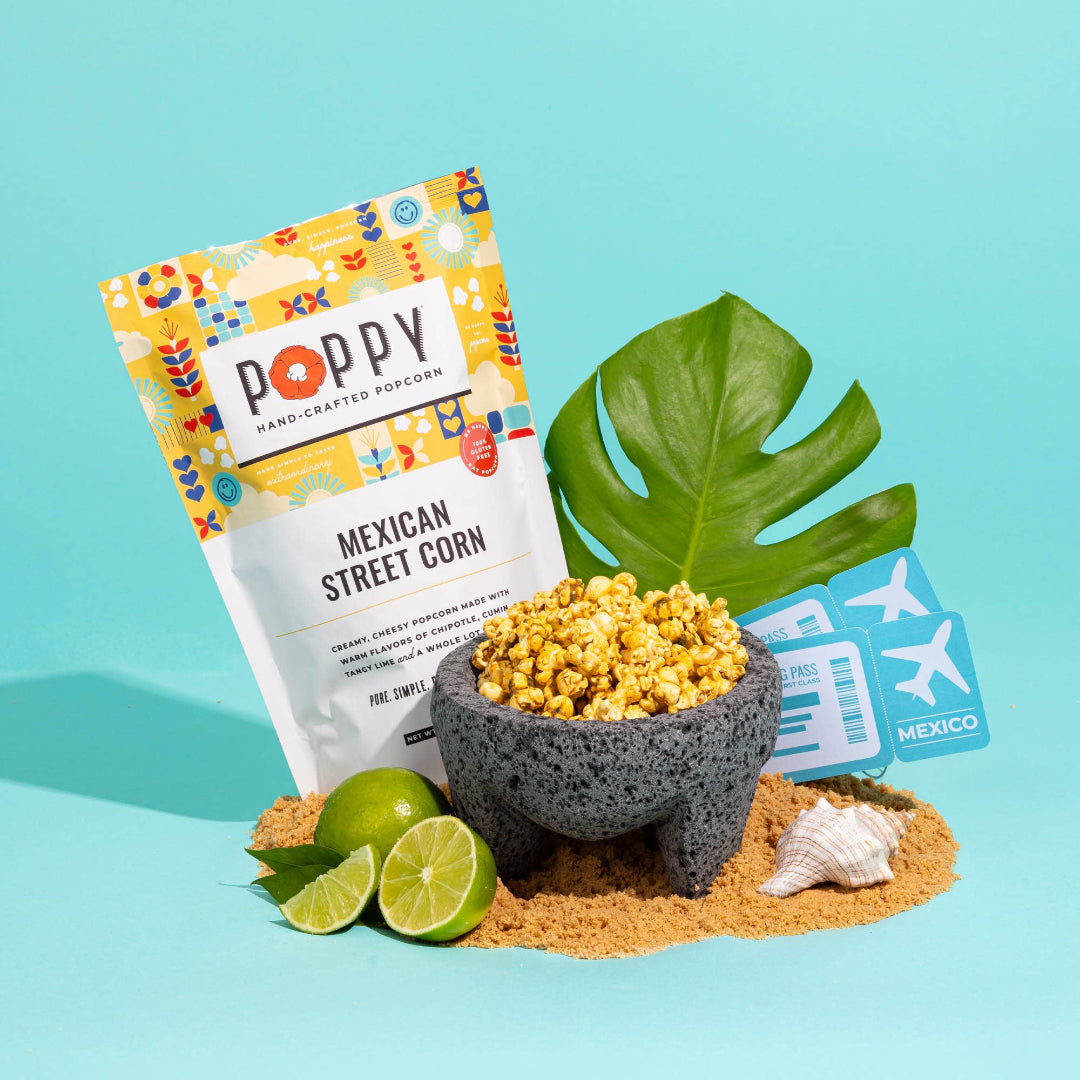 Poppy Mexican Street Corn popcorn package with a bowl of popcorn, limes, and a beach-themed card on a blue background