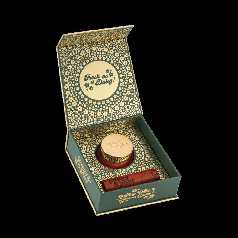 Poppy & Pout | Lip Care Duo, Cinnamint | An open box with a green container full of gold daisy accents.