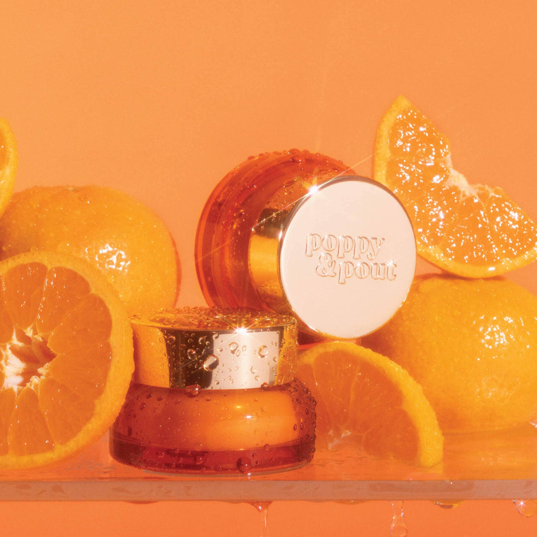 Orange skincare product with sliced oranges on an orange background