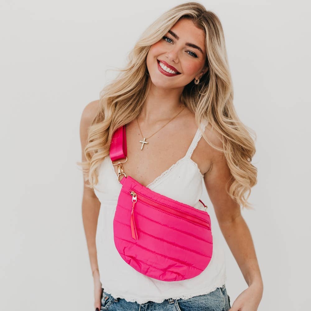 Pretty Simple | Jolie Puffer Belt Bag, bright pink on a model wearing a white shirt.