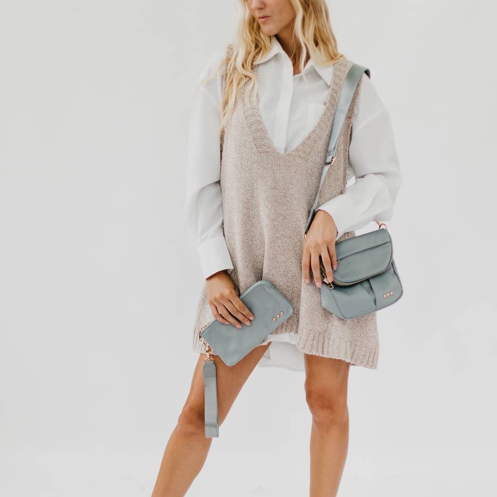 Pretty Simple | Tilly Crossbody Bag | Gray with gold accents. Model holds a matching wristlet wallet.