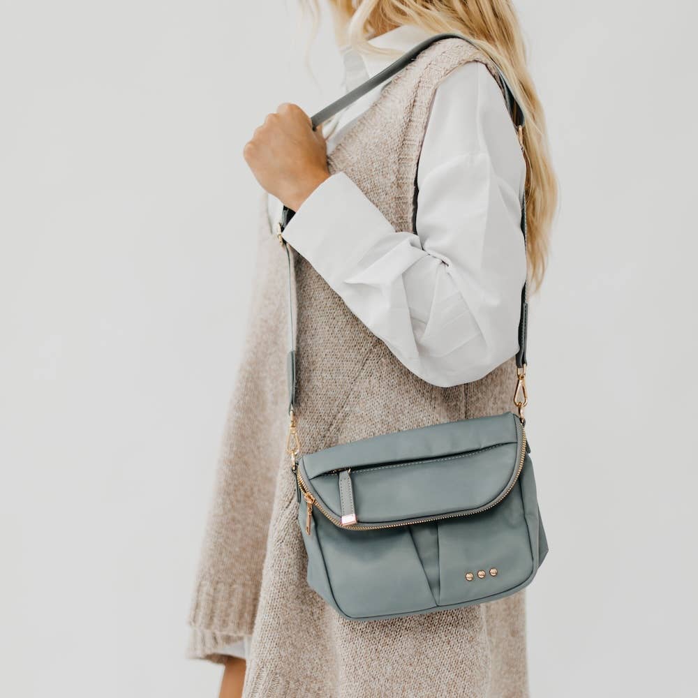 Pretty Simple | Tilly Crossbody Bag | Gray with gold accents. On a model wearing cream.
