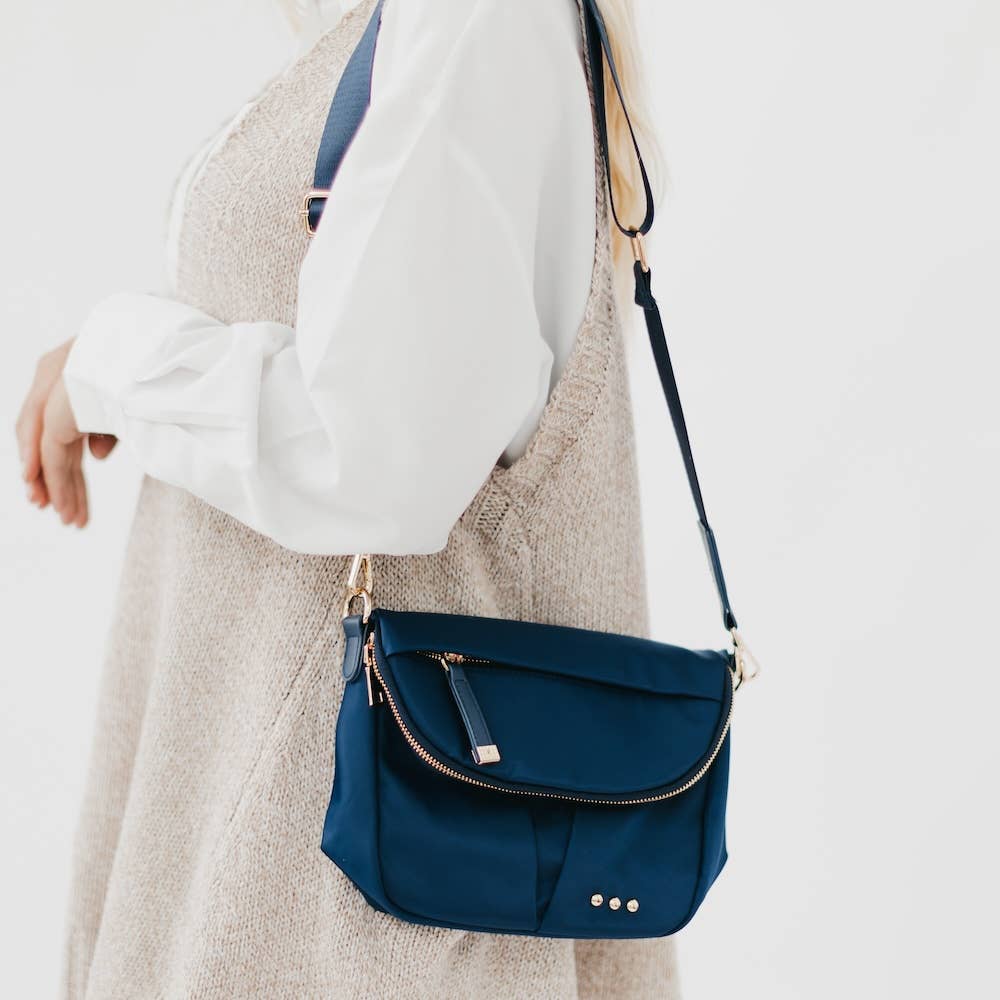 Pretty Simple | Tilly Crossbody Bag | Navy with gold accents. On a model wearing cream.