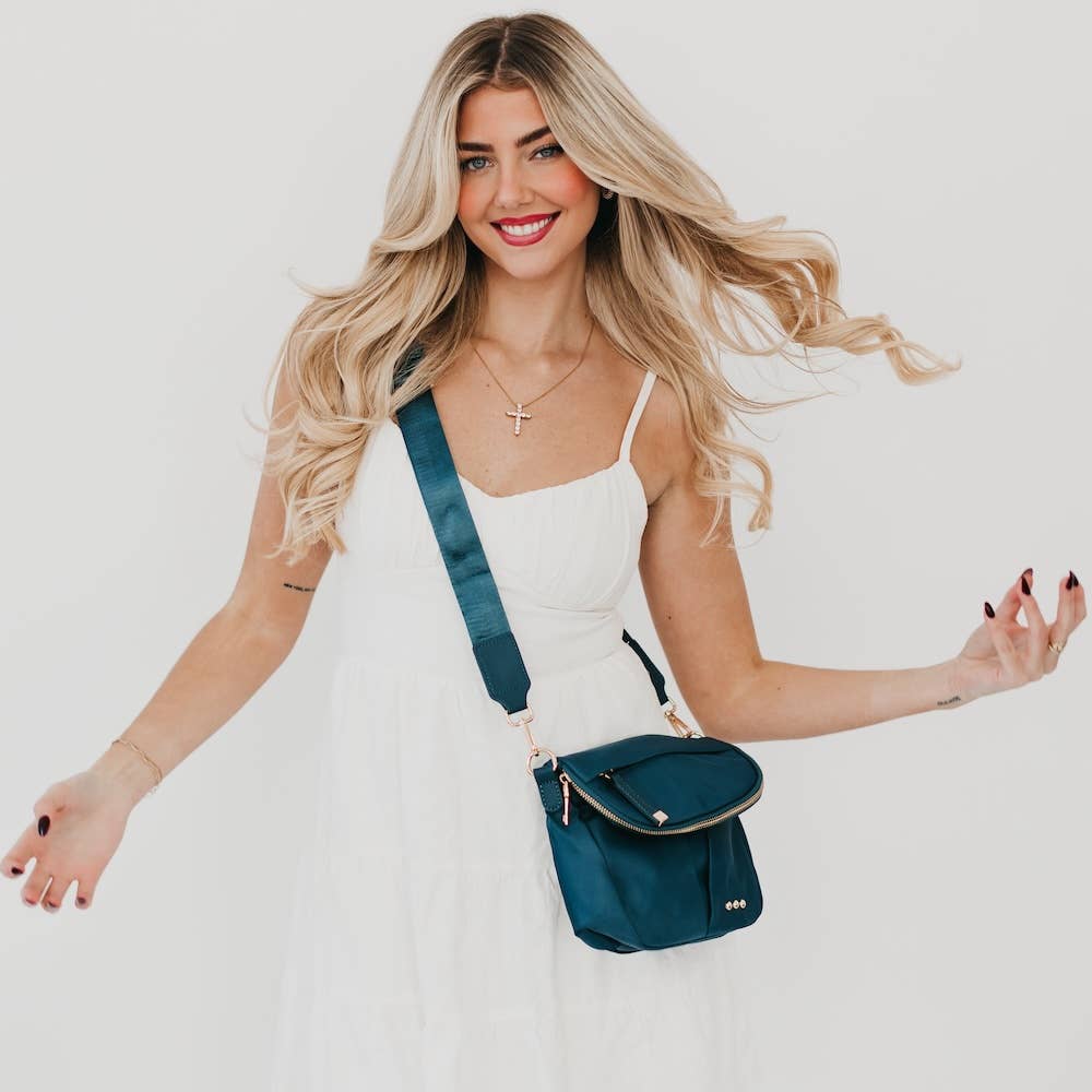 Pretty Simple | Tilly Crossbody Bag | Teal with gold hardware. On a model wearing white.