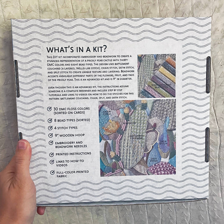 Kit information sheet with embroidery design on a textured surface