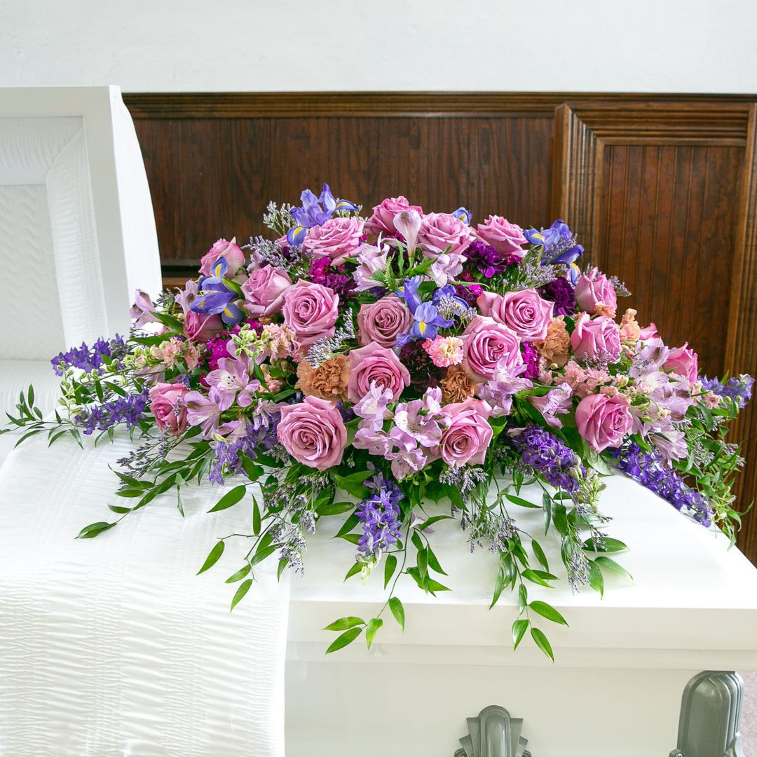 Colorful floral arrangement on a casket with a wooden background
