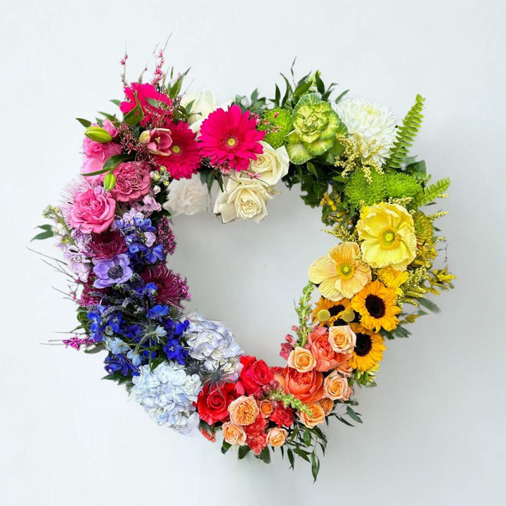 Stacy K Floral | Rainbow Heart Sympathy Wreath | A heart shaped arrangement with a rainbow of florals.