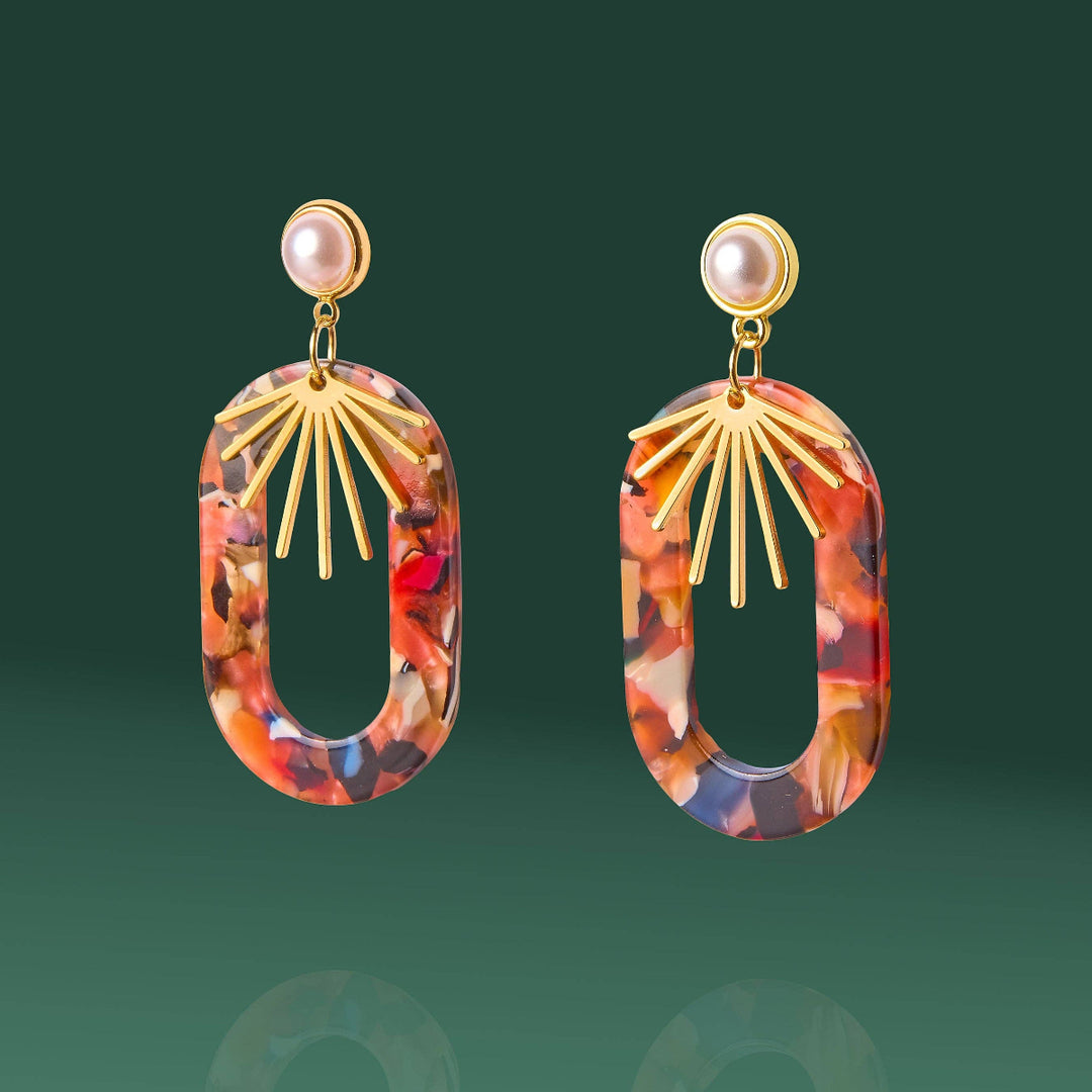 Pair of earrings with gold accents and multicolored oval stones on a green background