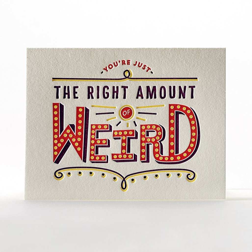 A white card with circus style text that reads "You're just the right amount if weird"