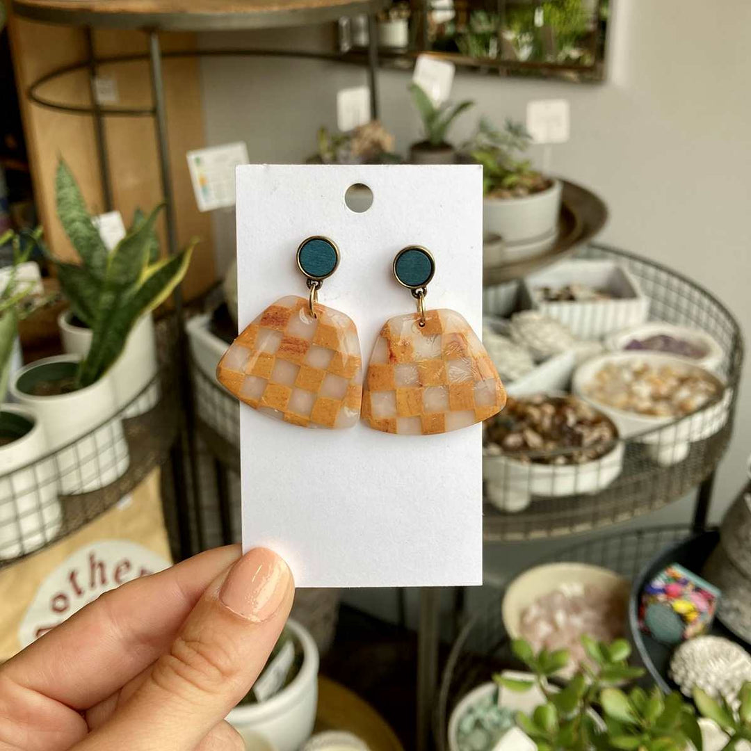 Rivergirl Curiosities | Checkered Polymer Clay Earrings |  Orange and clear checkered earrings with a teal accent stud.