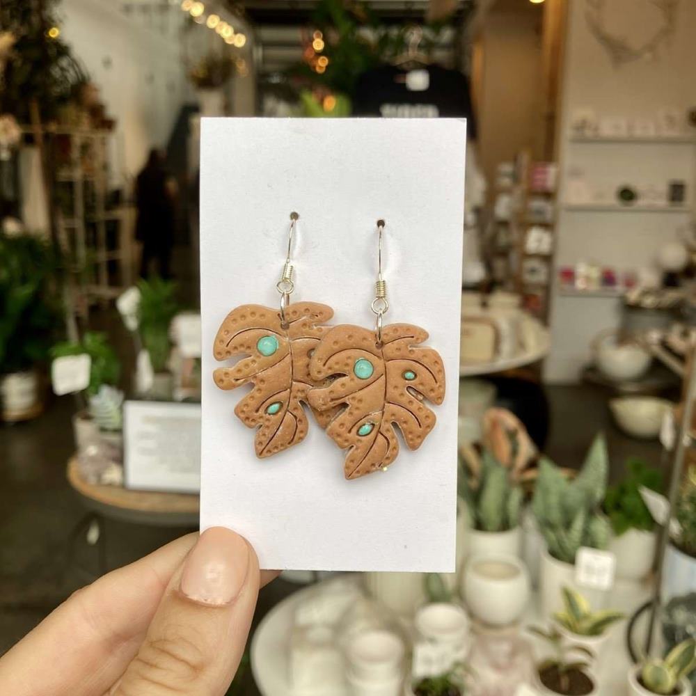 Rivergirl Curiosities | Monstera Leaf Polymer Clay Earrings | Brown monstera leaf earrings with turquoise spots.