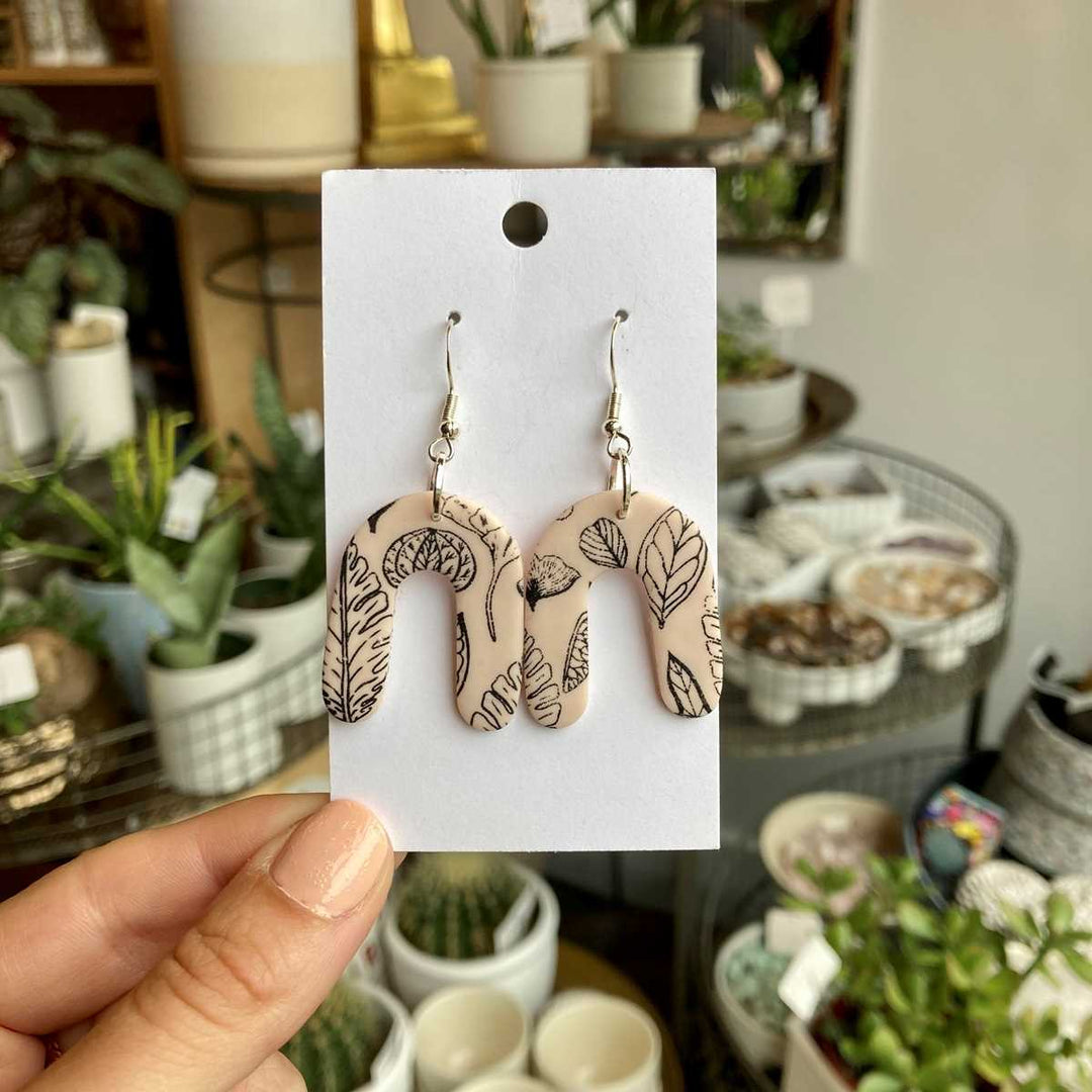 Rivergirl Curiosities | Plant Print Polymer Clay Earrings | Neutral colored earrings with a black fineline plant pattern.