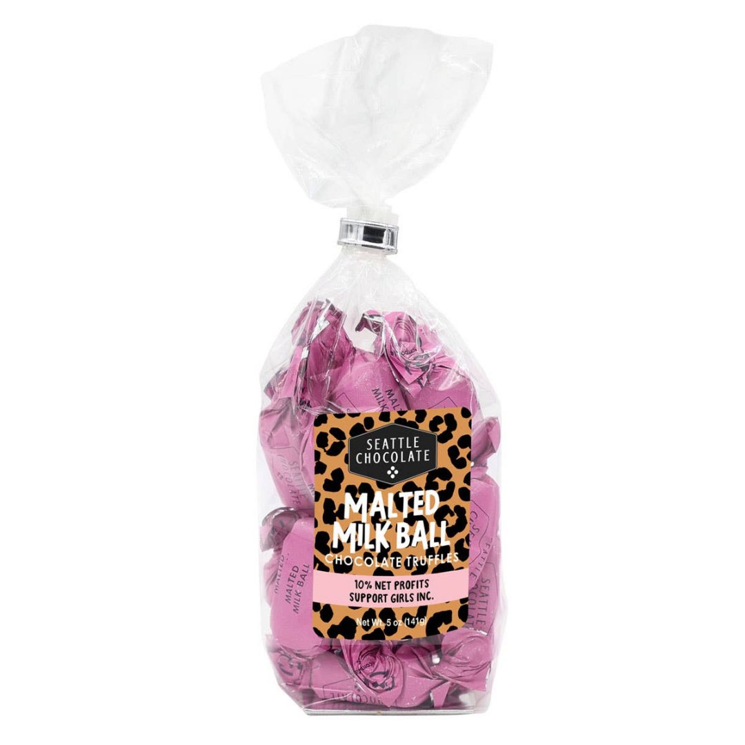 Malted Milk Ball Truffle Bag - 5 oz | A clear bag filled with pink individually wrapped malted milk balls. The label is leopard print with the text " Seattle Chocolate, malted milk ball chocolate truffles, 10% net profits support girls inc. Net Wt. 5oz (141g).