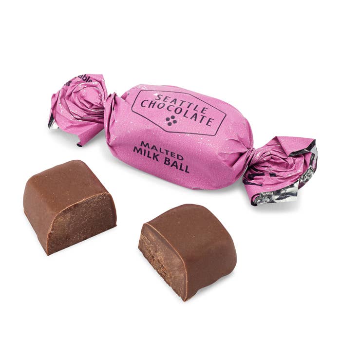 Malted Milk Ball Truffle Bag - 5 oz | Close up on the individually wrapped chocolates. Wrapper is pink.