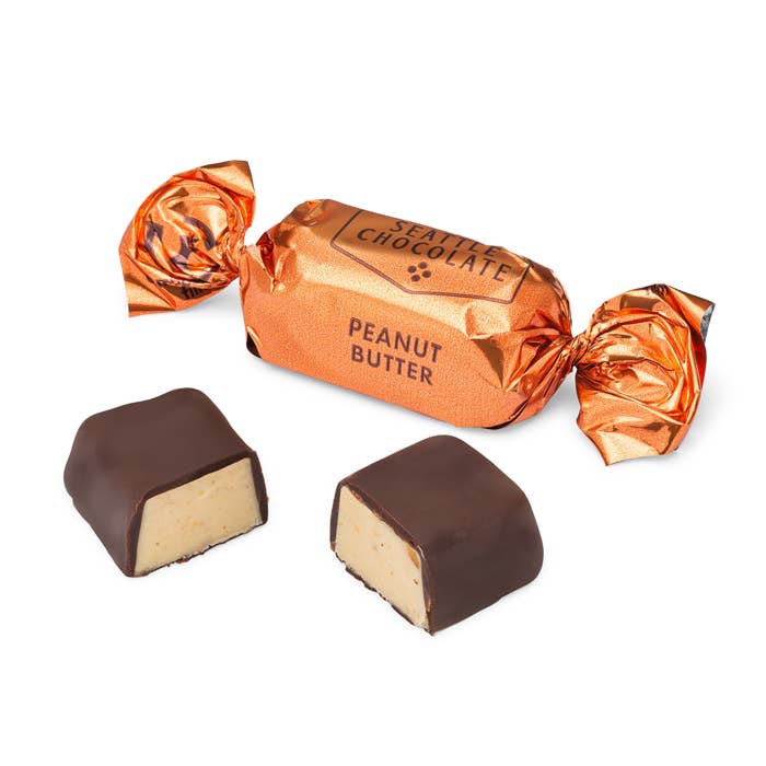 Peanut Butter Truffle Bag | Close up on an individually wrapped chocolate with an orange wrapper.