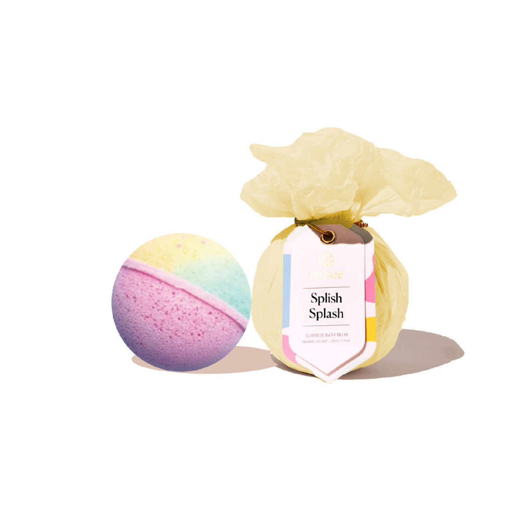 Colorful bath bomb with a yellow flower and 'Splash Splash' packaging on a white background