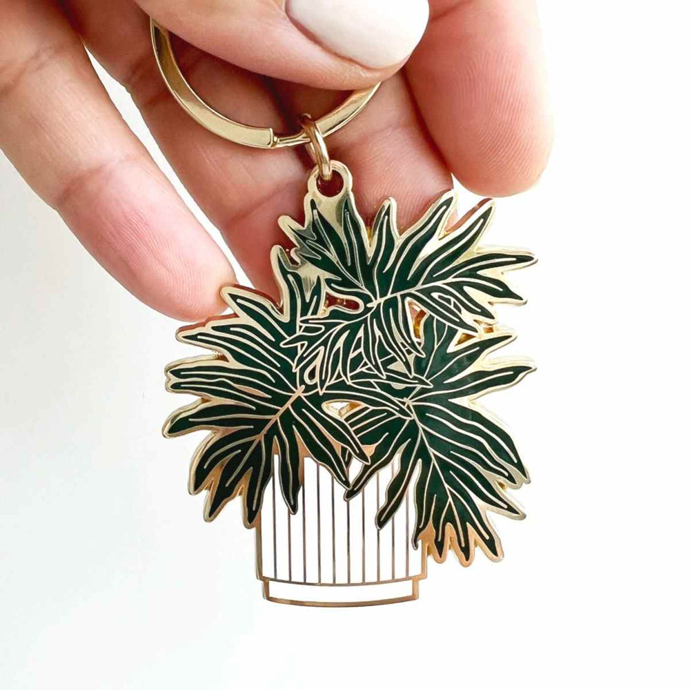 Split-Leaf Philodendron Plant Key | Close up on a plant in a white pot with gold accents.