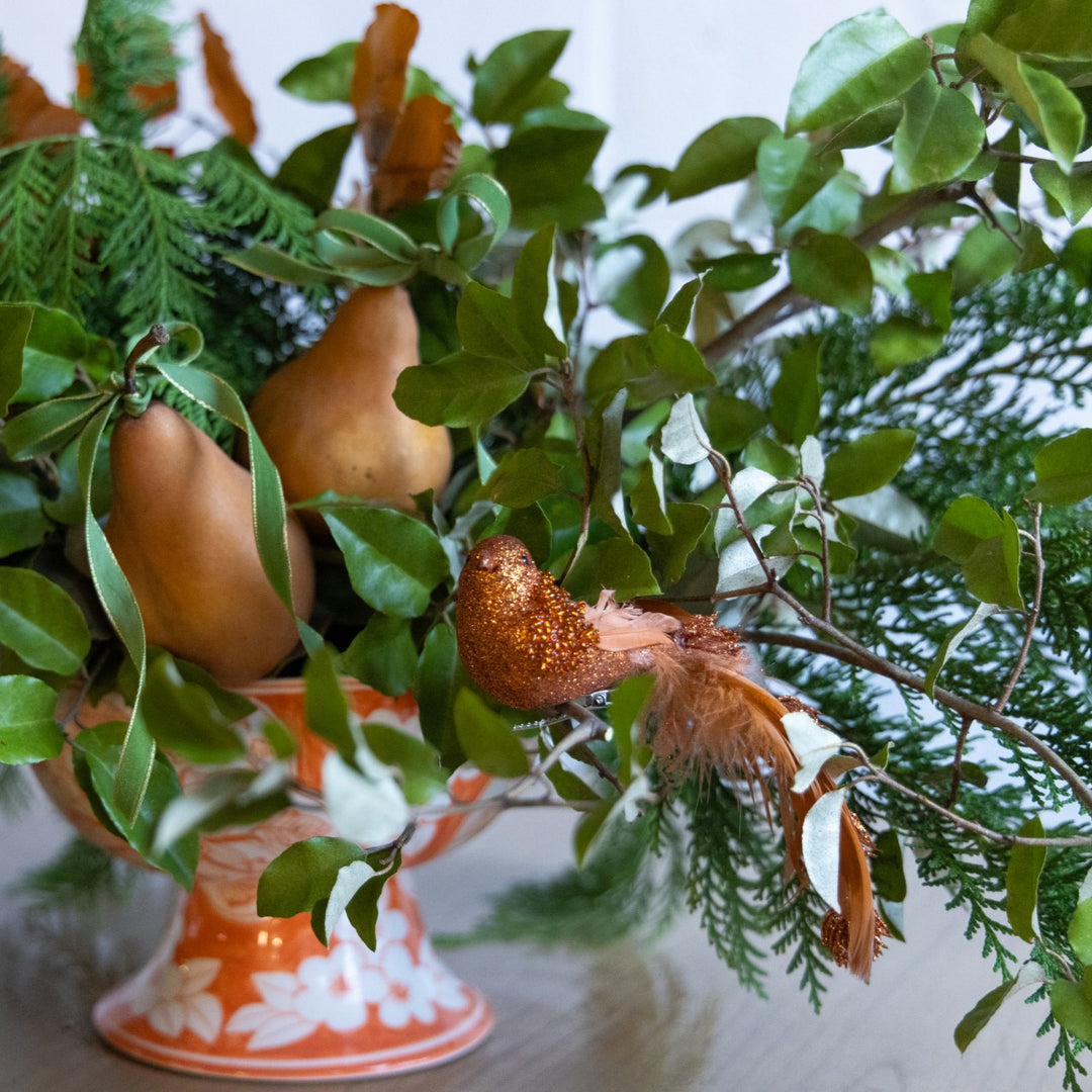Decorative gourds and leaves on a stand with a blurred background
