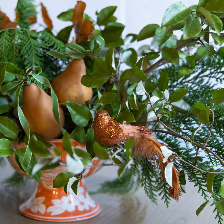 Decorative gourds and leaves on a stand with a blurred background