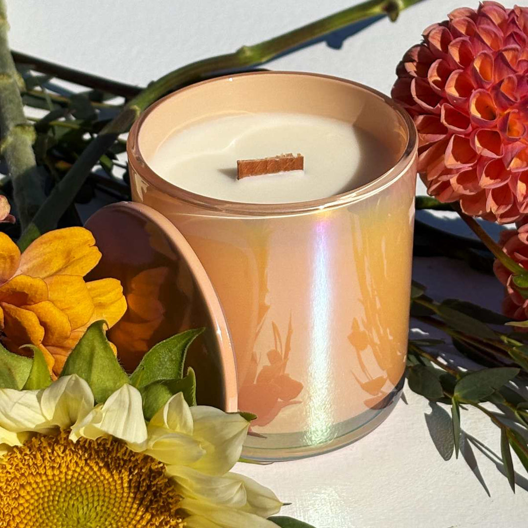 Stacy K Floral | Fleurish Co. | Fall Foliage | Wooden wick candle in an iridescent glass candle. Accented by fresh flowers such as dahlias, zinnia, and sunflowers.