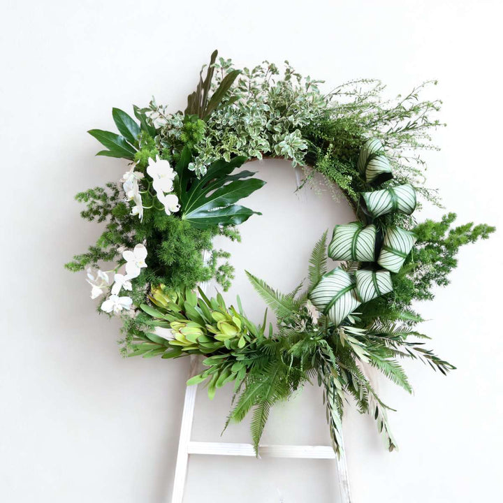 Stacy K Floral | Funeral wreath with greenery and orchids.