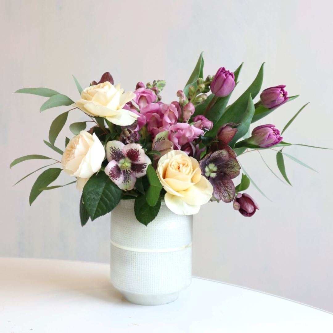 Stacy K Floral | Garden Symphony | A fresh floral arrangement with purples, greens, and cream. In a white vase.