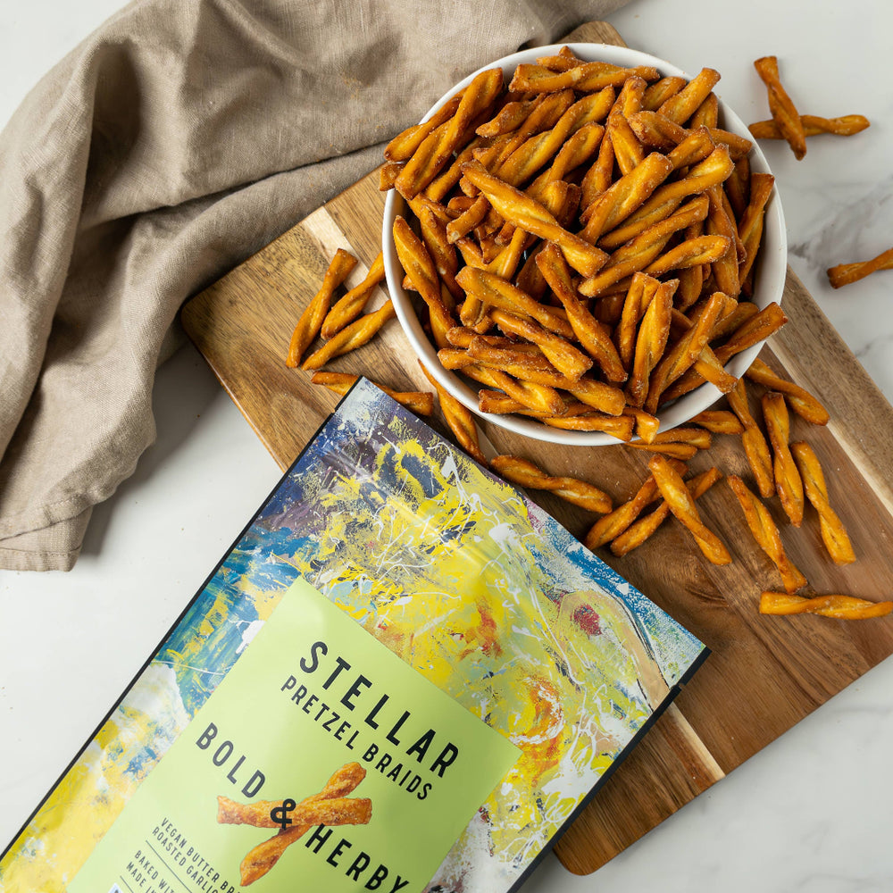 Stellar Pretzel Straws packaging with a bowl of pretzels on a wooden board.