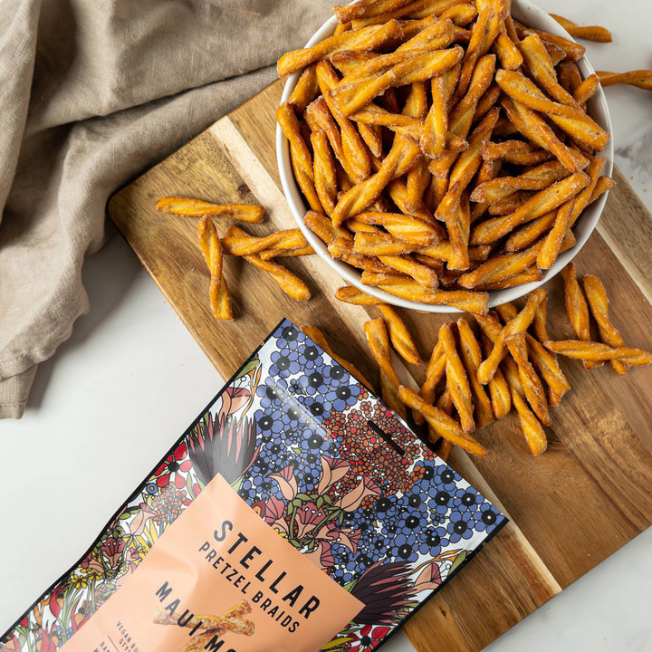 Stellar Navi Mona pretzel snacks on a wooden board with packaging.