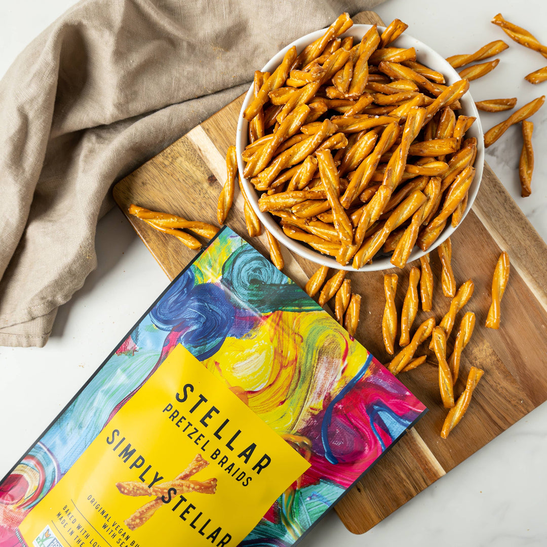 Stellar Simply Stellar pretzel brands packaging with pretzels on a wooden board.