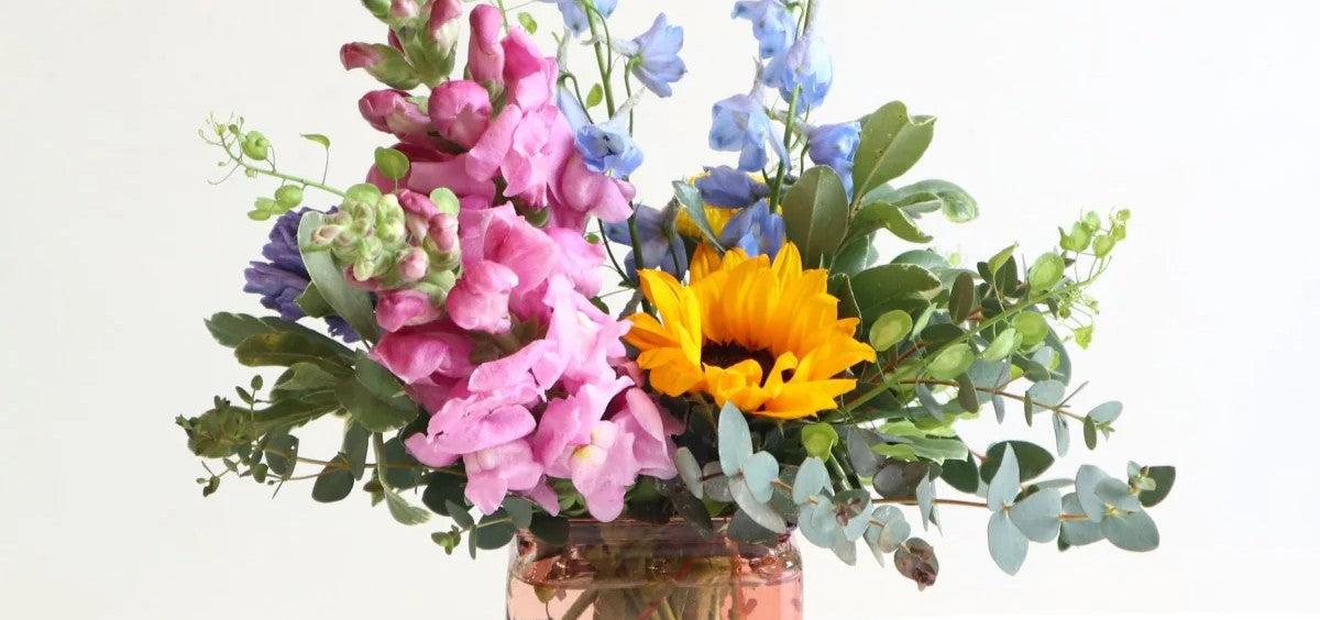 Stacy K Floral | Summer arrangement banner with snapdragons, delphinium,  sunflowers, and eucalyptus.