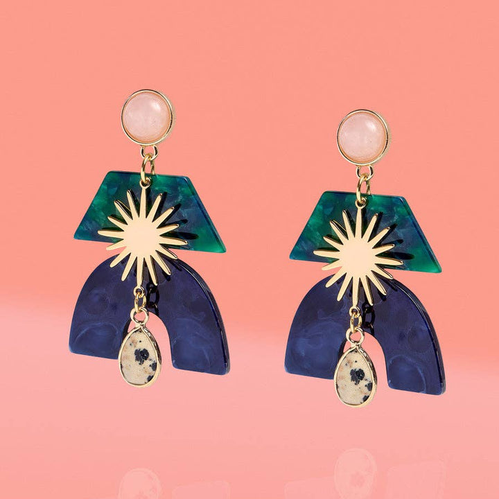 Pair of earrings with geometric design on a pink background