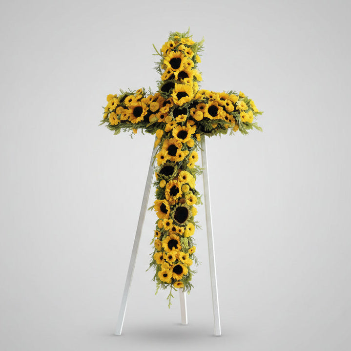 Floral cross arrangement with sunflowers on a white background