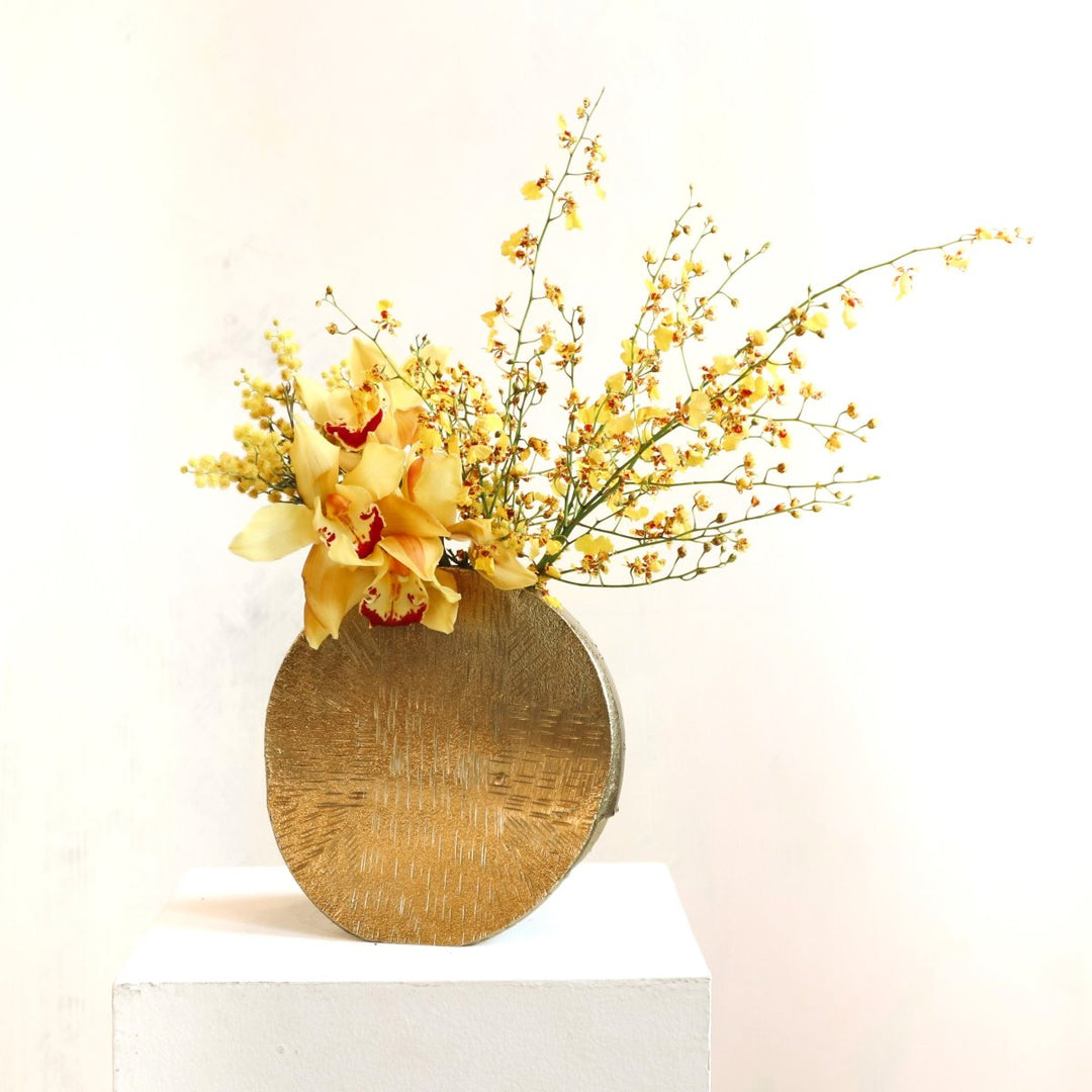 Stacy K Floral | Sunlight Arrangement | A textured gold vase full of yellow orchids.