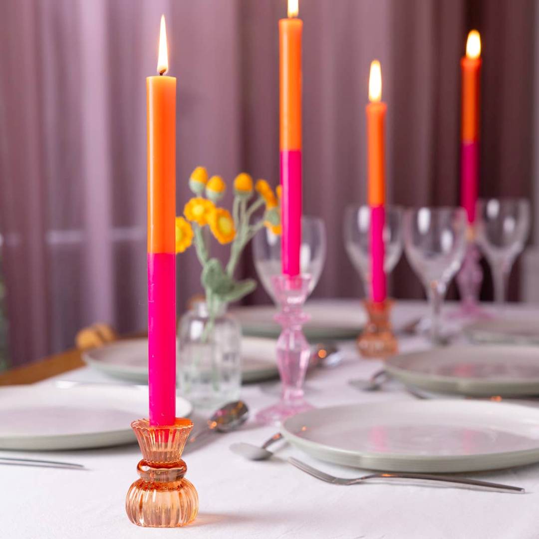 Talking Tables | Colorful candles on a table setting with plates and glasses.